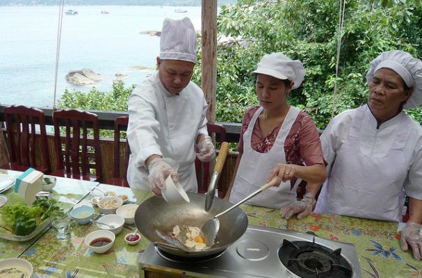  Woman teaching an online cooking class with ingredients and a laptop